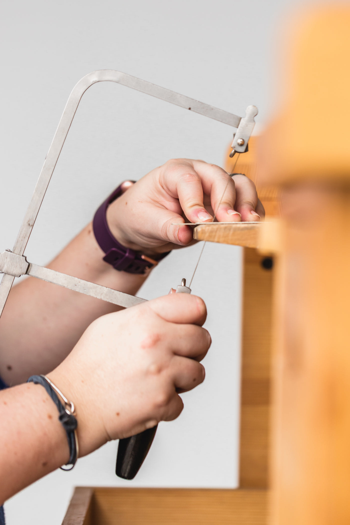 A maker working at the bench, holding a piece in a clamp