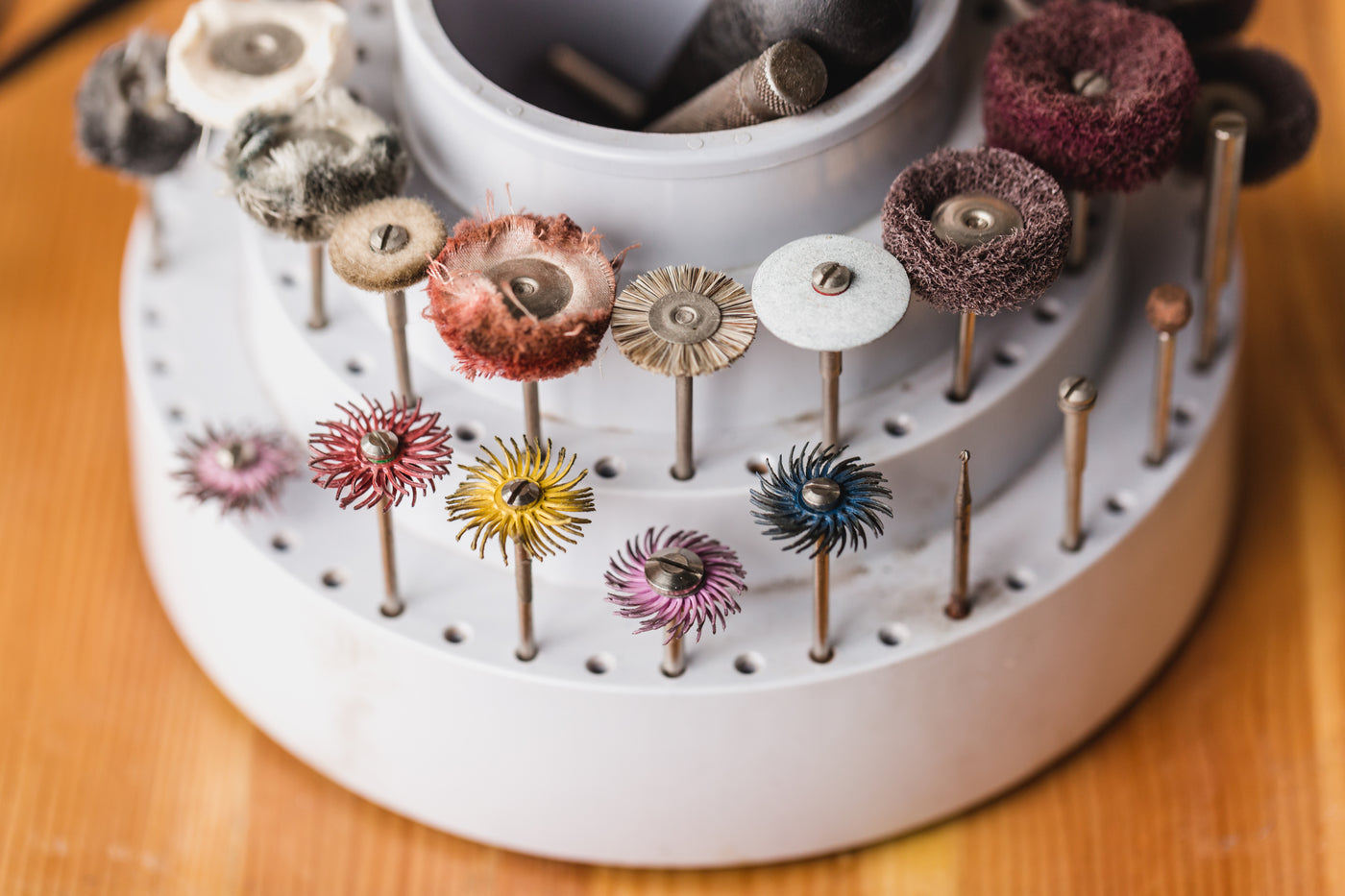 Coloured polishing wheels and mops arranged in a rotary stand