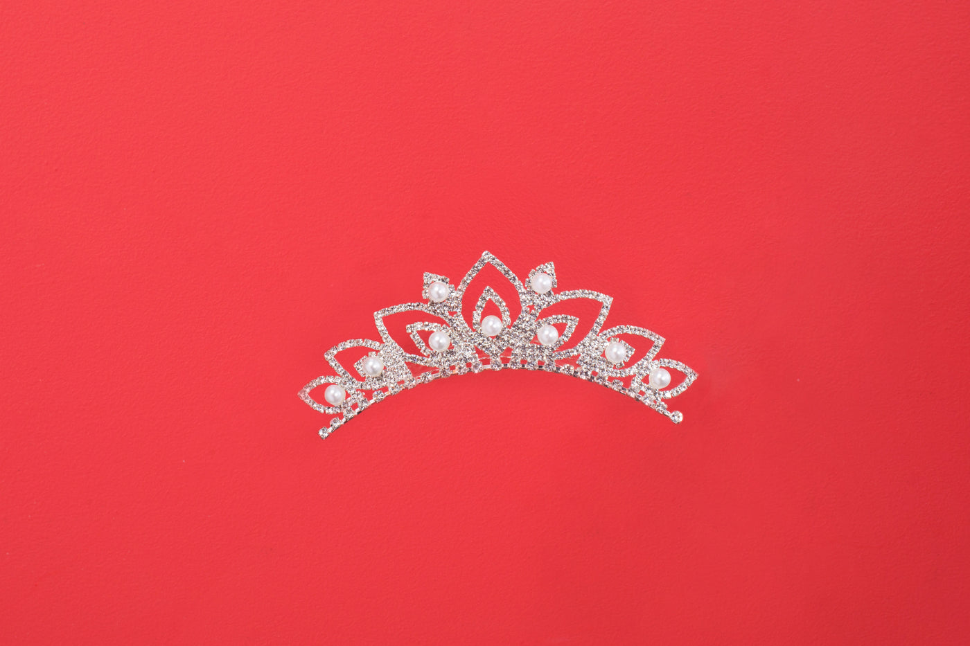 Crystal-set tiara photographed flat against a red ground